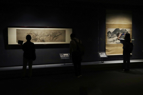 20일 오전 서울 용산구 국립중앙박물관에서 열린 '위대한 문화유산을 함께 누리다- 고 이건희 회장 기증 명품전' 언론 공개회에서 참석자들이 겸재 정선의 '인왕제색도(오른쪽)과 단원 김홍도의 '추성부도'를 살펴보고 있다. <연합뉴스>